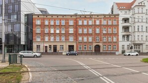 Vista de la calle con un edificio de varios pisos que combina arquitectura moderna y tradicional.