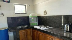 Een keuken met een spoelbak, fornuis en kastjes.