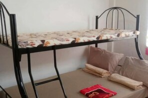 Una cama litera con una colcha estampada y almohadas en la cama inferior.