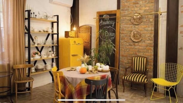 A cozy dining area with a brick wall, a chalkboard menu, and a yellow table. - Fotofabrika - Unique Beautiful 3 Storeys House (Oskemen)