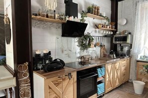 A kitchen with wooden cabinets, a microwave, a coffee maker, and various kitchen utensils. - Fotofabrika - Unique Beautiful 3 Storeys House (Oskemen)