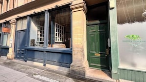A building facade with large windows and a green door, labeled "Indian Restaurant."