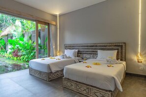 Una habitación con dos camas, un ventanal y vistas al exterior con vegetación.