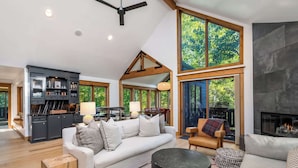 A spacious living room with a fireplace, a dining area, and a kitchen. - Evergreen Escape - Home for 10 (Vail)