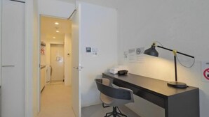 A small office space with a desk, chair, and a lamp. There is a door leading to another room. - Fandina Tokyo (Tokyo)