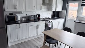 Una cucina moderna con mobili bianchi, un tavolo da pranzo e sedie.
