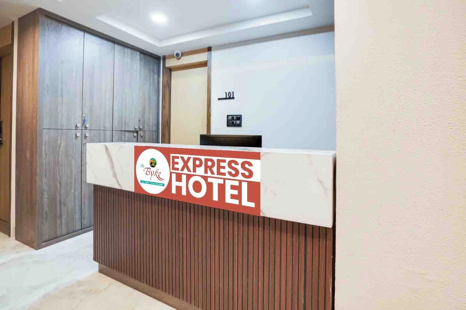 A reception desk with a sign for 'Express Hotel' and a wooden panel design.
