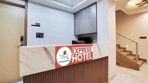 Una recepción con el letrero del Hotel Express, una escalera y una puerta con un número.