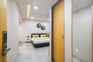 A modern hotel room with a bed, bedside table, and a wall-mounted artwork. - The Byke Express - Near Gopur Square (Indore)