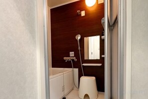 Une salle de bain avec une baignoire, des toilettes et une douche.