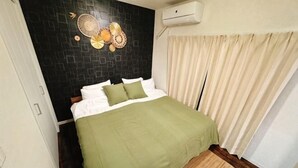 A bedroom with a bed, a wall-mounted air conditioner, and a window with curtains. - 【Color Nook1】Central Tokyo 15min／Narita 1hr！Station 10min walk！Newly renovated apartment (Tokyo)