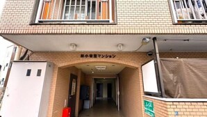 A building entrance with a brick facade, a covered walkway, and a sign indicating a business or service area. - 【Color Nook1】Central Tokyo 15min／Narita 1hr！Station 10min walk！Newly renovated apartment (Tokyo)