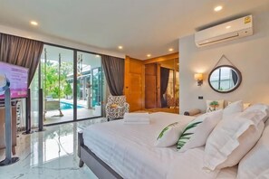 A hotel room with a large bed, a TV, a sliding glass door to a pool, and a view of the outdoors. - Hi At Home Villa 4 (Pattaya)