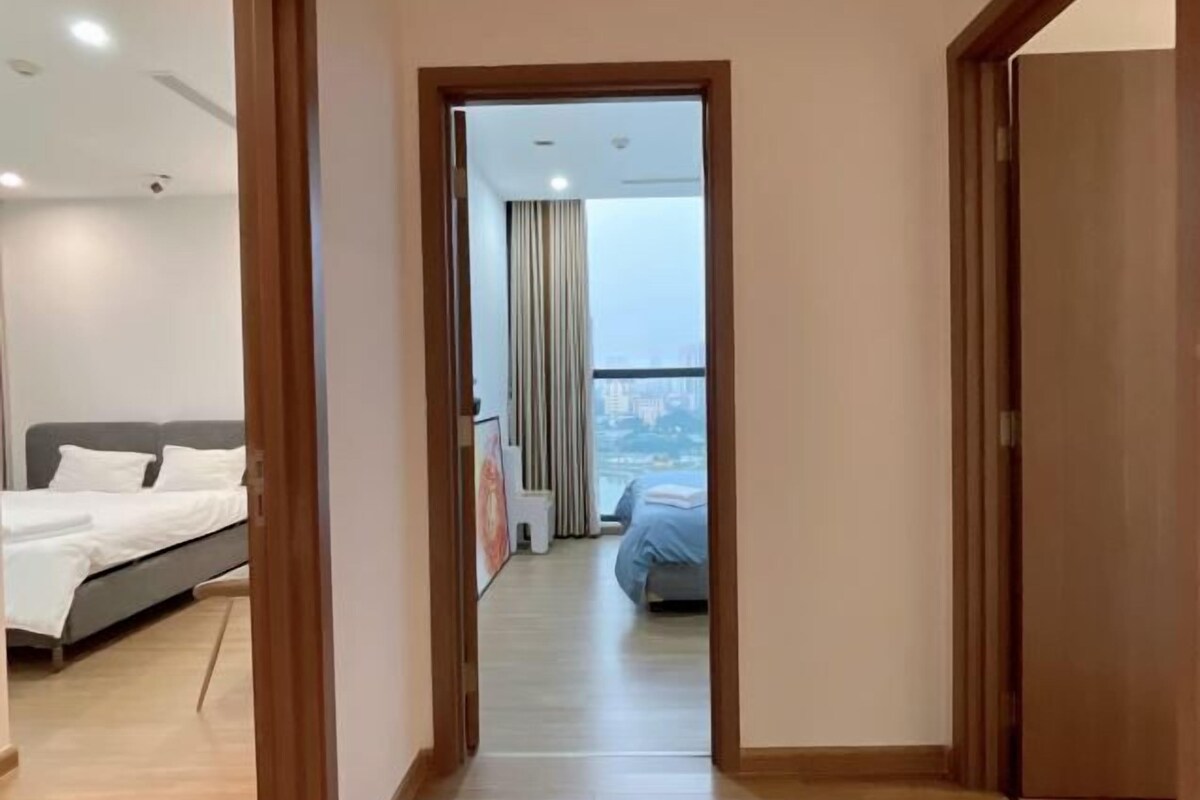 Une chambre d’hôtel avec un lit, une petite table et une vue sur la ville grâce à de grandes fenêtres.