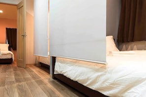 A hotel room with a bed, a door, and a view of the outside. - Yoshifukuya (Osaka)