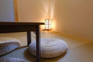 Tatami mats, a low table, and a wall-mounted light fixture. - Yoshifukuya (Osaka)