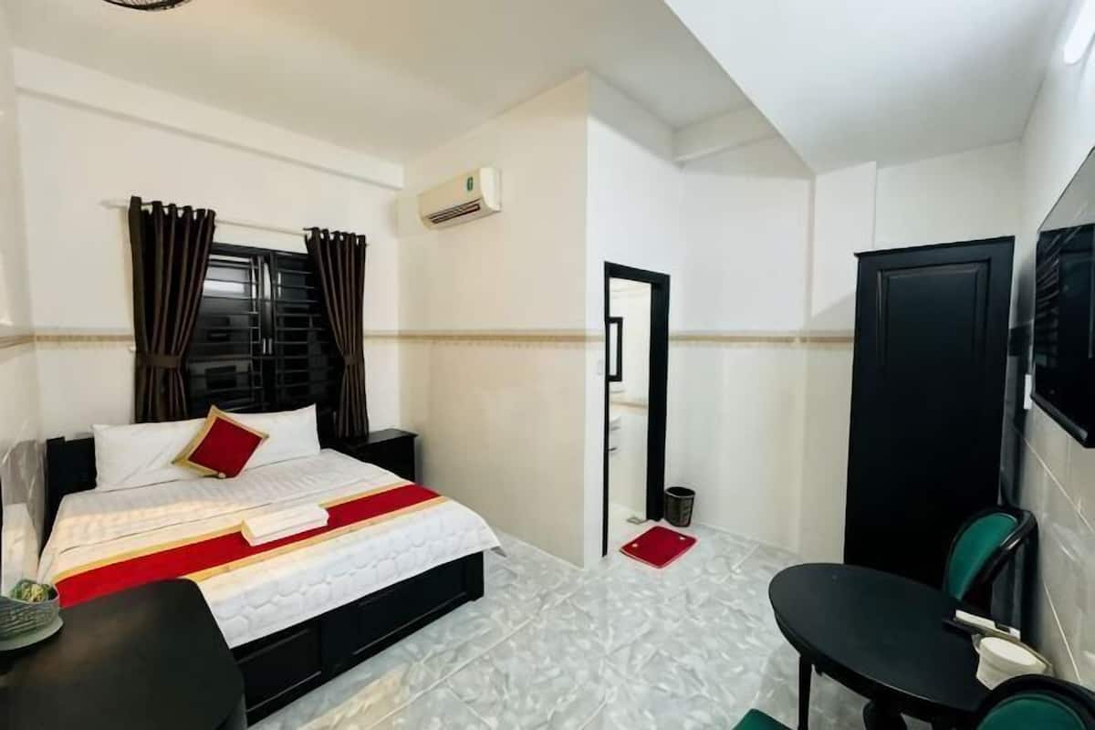 Ein Hotelzimmer mit Bett, Schreibtisch, Stuhl, Fernseher und Tür.