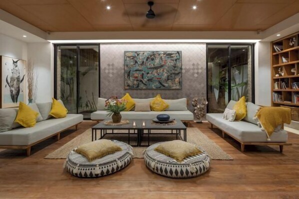 A modern living room with a sofa set, coffee table, and decorative pillows. - Pantai Indah Villa (Bali)