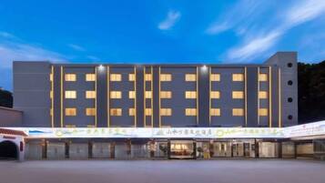Een modern hotel met een symmetrische gevel, meerdere verdiepingen en een rij ramen.