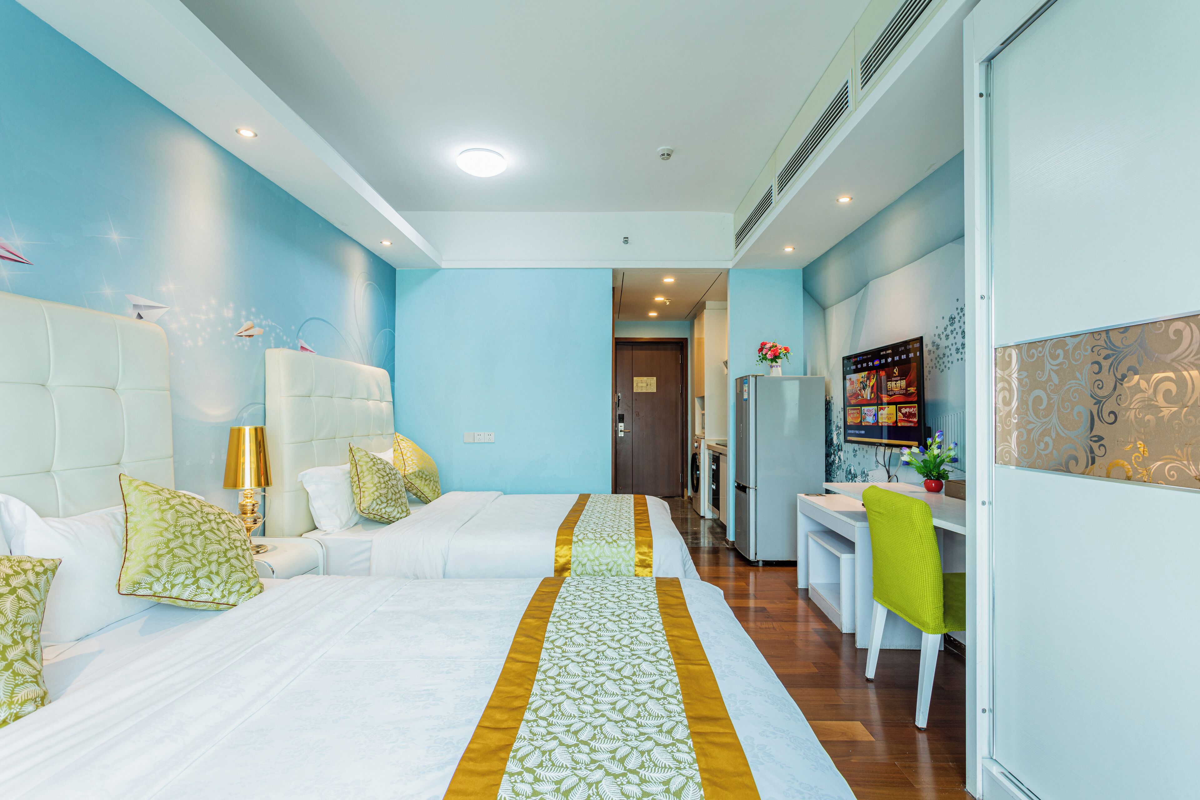 A hotel room with two beds, a dining area, and a kitchen.