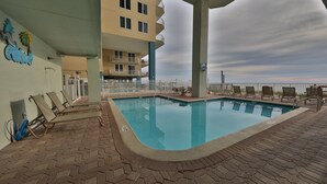 A swimming pool with lounge chairs, a covered area, and a view of the ocean. - Relax in Rare Low-Density Luxury – Marisol 3BR Beachfront Condo (Panama City Beach)