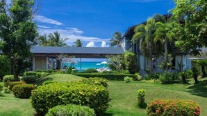 A hotel with a well-maintained garden, a pool area, and a view of the sea. - Sava Villa 5 Villa Malee Sai (Takua Thung)