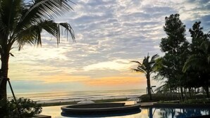 A pool with a view of the ocean and palm trees. - Deluxe Holiday Studio Suite @ Timurbay w/ Seaview (Kuantan)