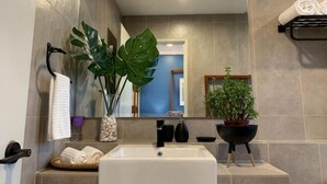A bathroom with a sink, mirror, potted plants, and towels. - Deluxe Holiday Studio Suite @ Timurbay w/ Seaview (Kuantan)