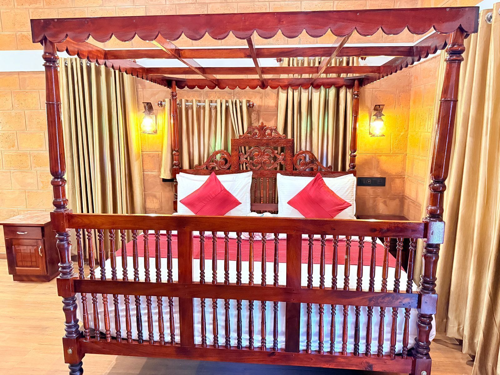 A four-poster canopy bed with a wooden frame and a red and white bedspread.