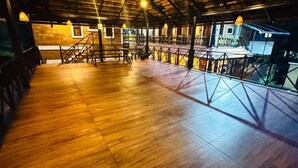 An indoor area with a wooden floor, metal railings, and a view of a building outside. - CREDIBLE HERITAGE RESORT (Varkala)
