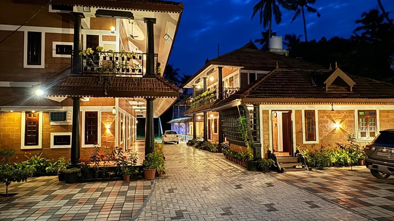 Rua residencial bem iluminada, com casas que têm varandas e plantas em vasos.