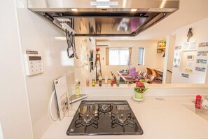 A kitchen with a gas stove, a wall-mounted oven, and a small countertop.