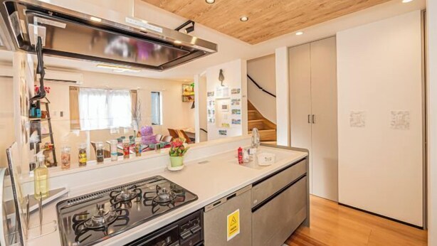 Una cocina moderna con estufa a gas, electrodomésticos de acero inoxidable y techo de madera.