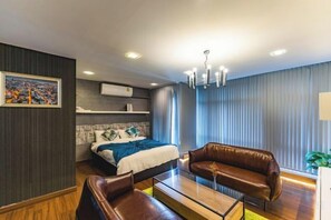 A modern hotel room with a bed, a sofa, a coffee table, and a large window with curtains. - Baan PromTel , Luxury Villa close to Nimman, Resort Pool, 4BR (Chiang Mai)