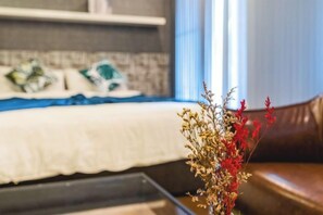 A bedroom with a bed, a window, and a vase with dried flowers. - Baan PromTel , Luxury Villa close to Nimman, Resort Pool, 4BR (Chiang Mai)