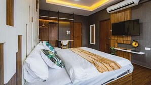 A modern bedroom with a bed, a TV, and an air conditioning unit. - Baan PromTel , Luxury Villa close to Nimman, Resort Pool, 4BR (Chiang Mai)