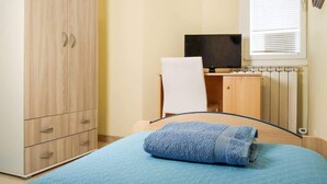 Een slaapkamer met een bed, een bureau, een stoel en een kledingkast.