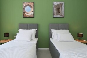 A hotel room with two beds, green walls, and framed pictures above the beds. - Steps from Palace & Riva - Old Town Pine (Split)