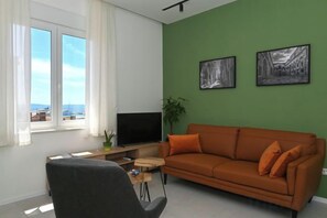 A living room with a green wall, a brown sofa, a black TV, and a window with curtains. - Steps from Palace & Riva - Old Town Pine (Split)