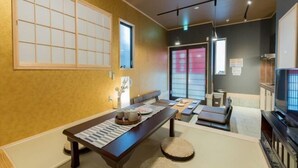 A traditional Japanese-style room with tatami flooring, a low table with cushions, and sliding doors. - Yadoya Negishi (Tokyo)