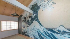 A room with tatami flooring, a shoji screen, and a Japanese-style wall mural. - Yadoya Negishi (Tokyo)