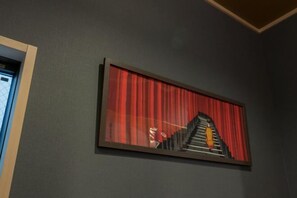 A framed artwork depicting a staircase with a person ascending, set against a dark wall. - Yadoya Negishi (Tokyo)