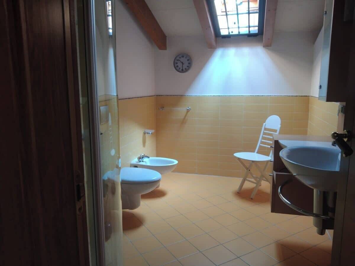 A bathroom with two toilets, a bidet, and a sink.