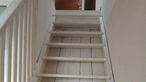 Een trap met witte leuningen en houten treden.