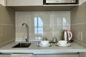 A modern kitchen with a stainless steel sink, a kettle, and a toaster. - KLCity & KLCC View Modern Style 2R2B - 6 pax (Kuala Lumpur)