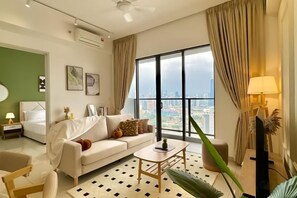 A modern hotel room with a large window, a sofa, a coffee table, and a bed. - KLCity & KLCC View Modern Style 2R2B - 6 pax (Kuala Lumpur)