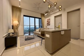 A modern hotel room with a sofa, a small table, a kitchen area, and a large window offering a city view. - KLCity & KLCC View Modern Style 2R2B - 6 pax (Kuala Lumpur)