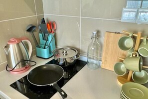 A kitchen with a stove, pots, a kettle, and a coffee maker. - KLCity & KLCC View Modern Style 2R2B - 6 pax (Kuala Lumpur)