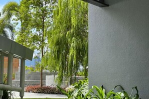 A building exterior with a grey wall, a hanging plant, and a concrete structure in the background. - KLCity & KLCC View Modern Style 2R2B - 6 pax (Kuala Lumpur)