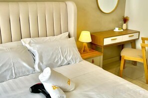 A neatly made bed with pillows, a bedside table with a lamp, a wooden desk, and a chair. - KLCity & KLCC View Modern Style 2R2B - 6 pax (Kuala Lumpur)